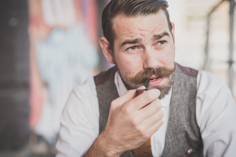 handsome big moustache hipster man smoking pipe