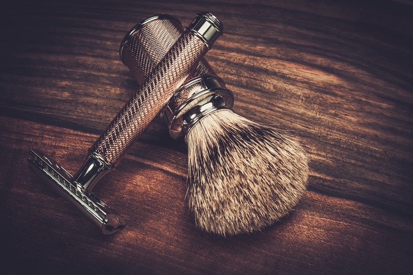 Safety razor and shaving brush on a wooden background 