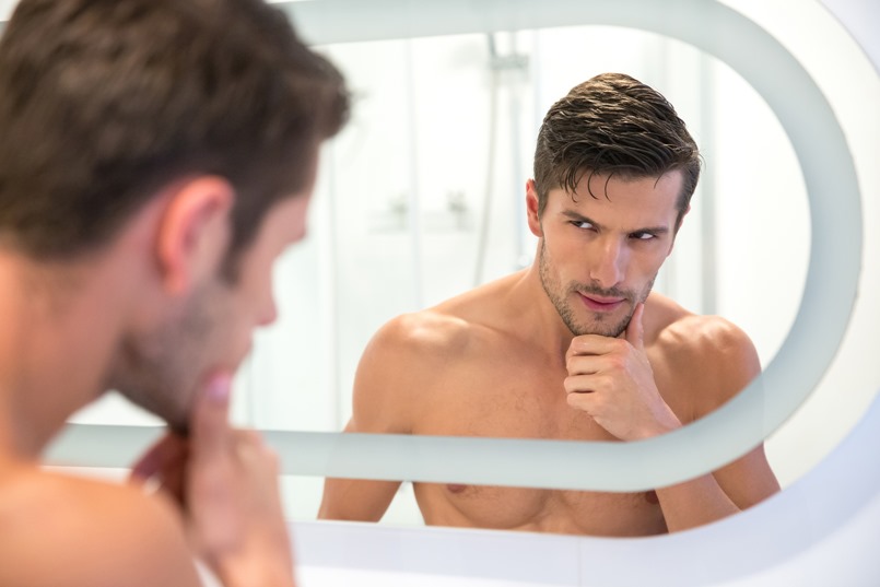Man looking at his reflection in the mirror