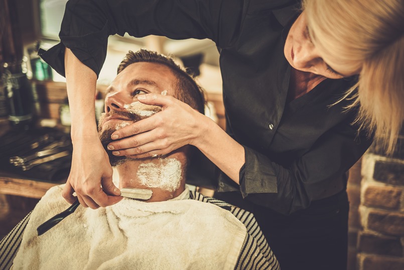 Client during beard shaving in barber shop